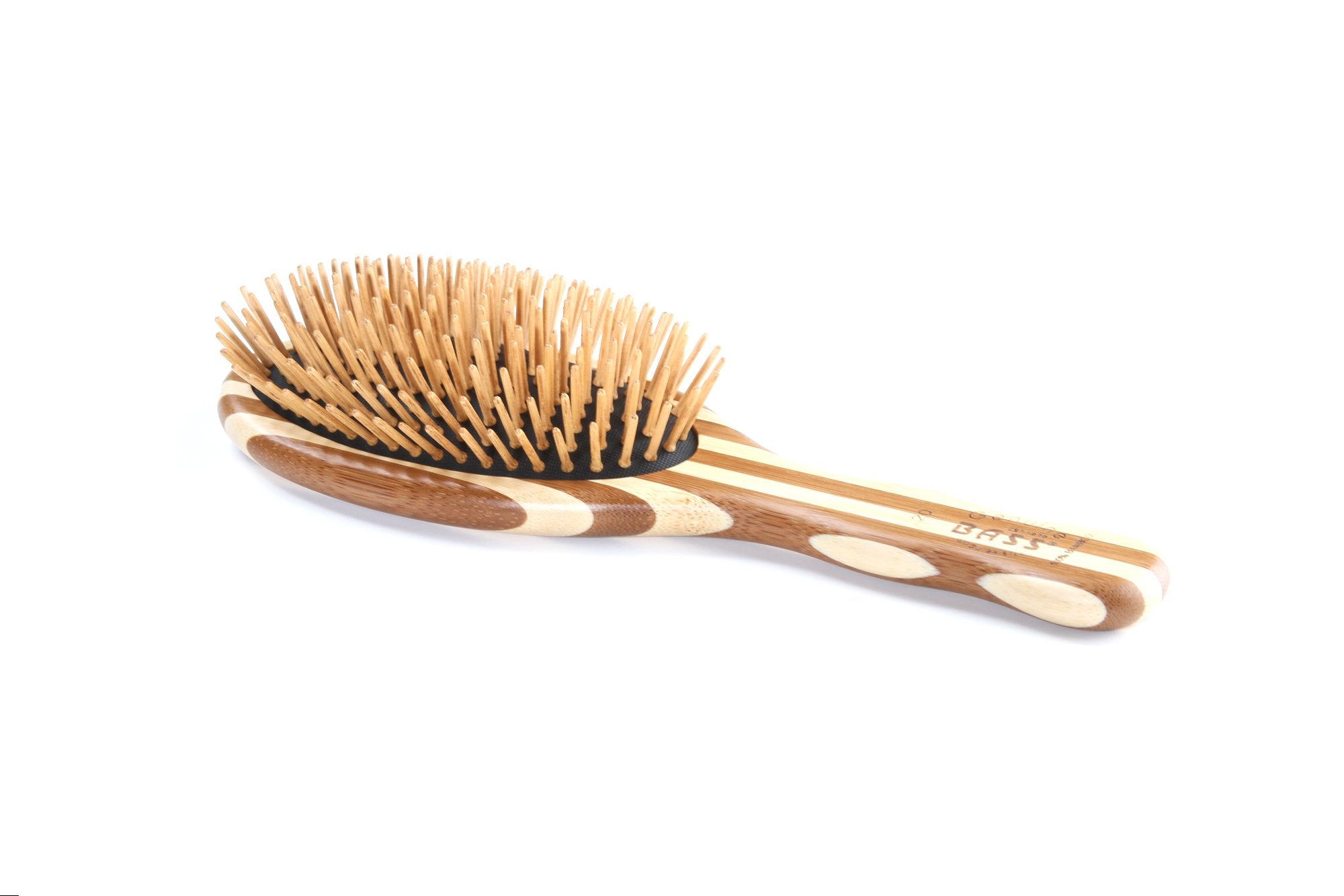 Bass Green Brush in use with a blow dryer for smooth, heat-tolerant styling.