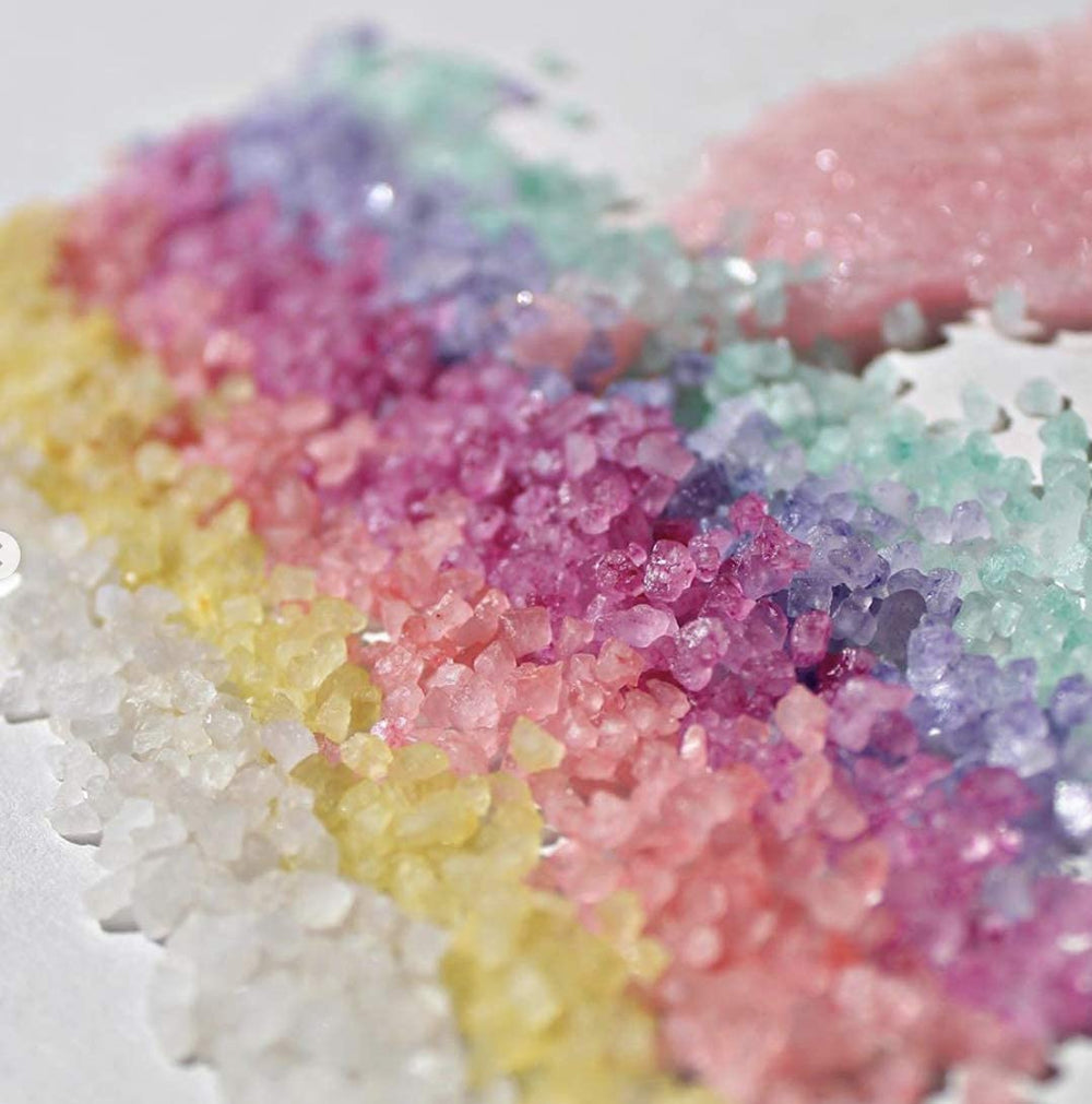Close-up of Bella & Bear Paradise Fruits bath salt crystals dissolving to release fruity aroma.