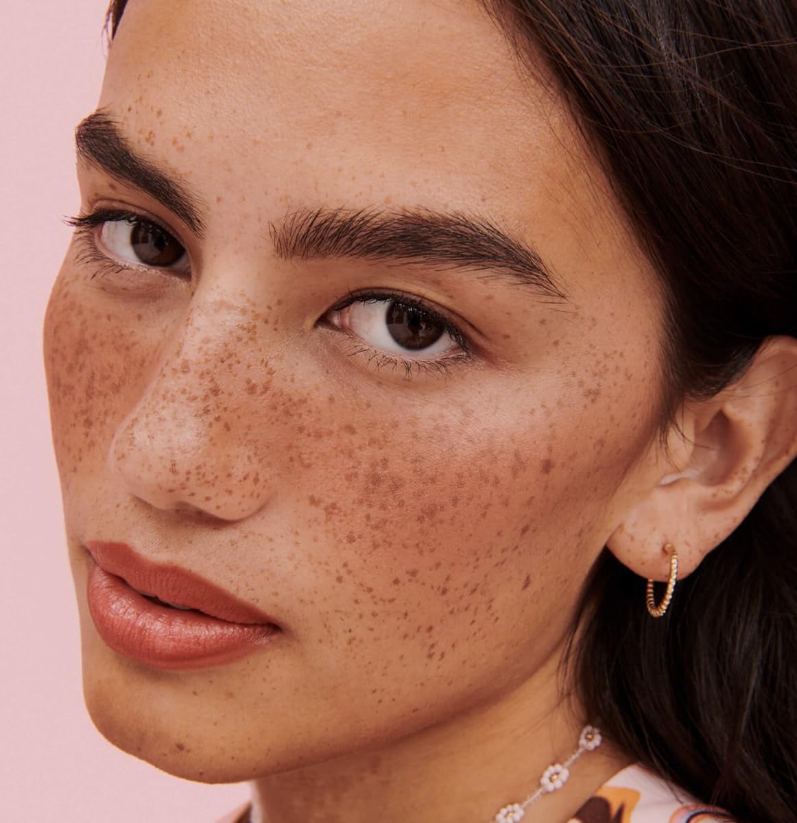 Benefit applying Rosy Mocha with cheek brush for even, buildable color benefit
