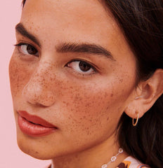 Benefit applying Rosy Mocha with cheek brush for even, buildable color benefit