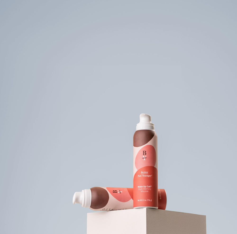 Vanity setup with Better Not Younger volumizing mousse for quick daily styling.