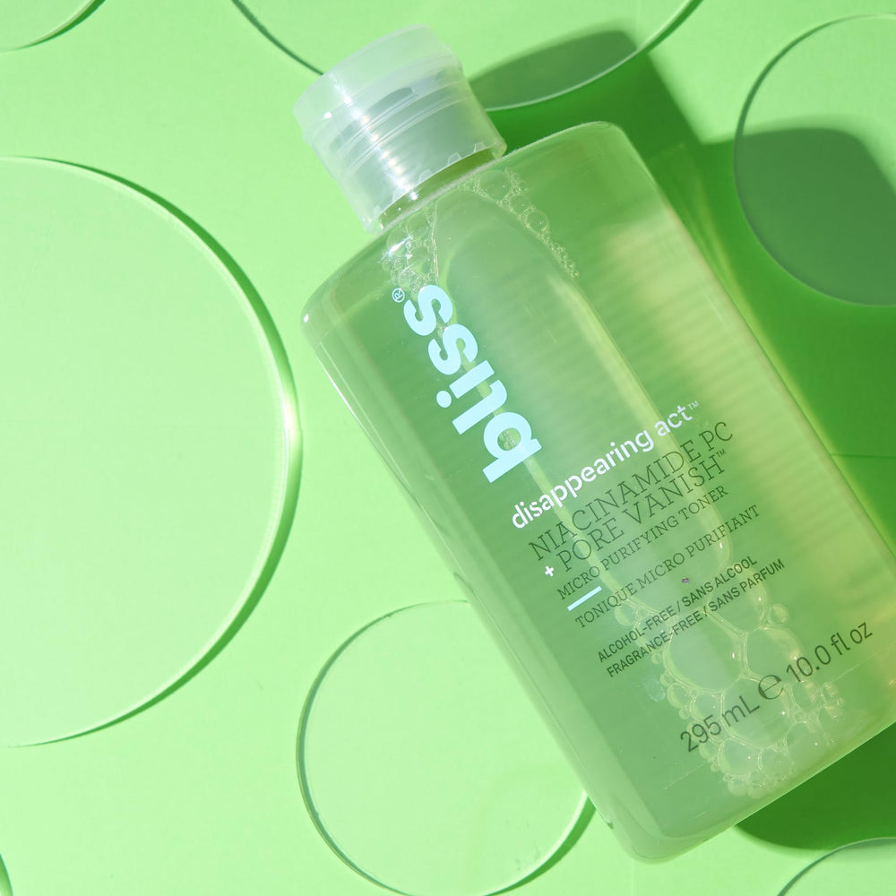 Bliss Disappearing Act Toner bottle beside glass conveys fragrance-free formula.