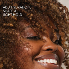 BONDIBOOST styling cream in hand ready to apply for controlled definition