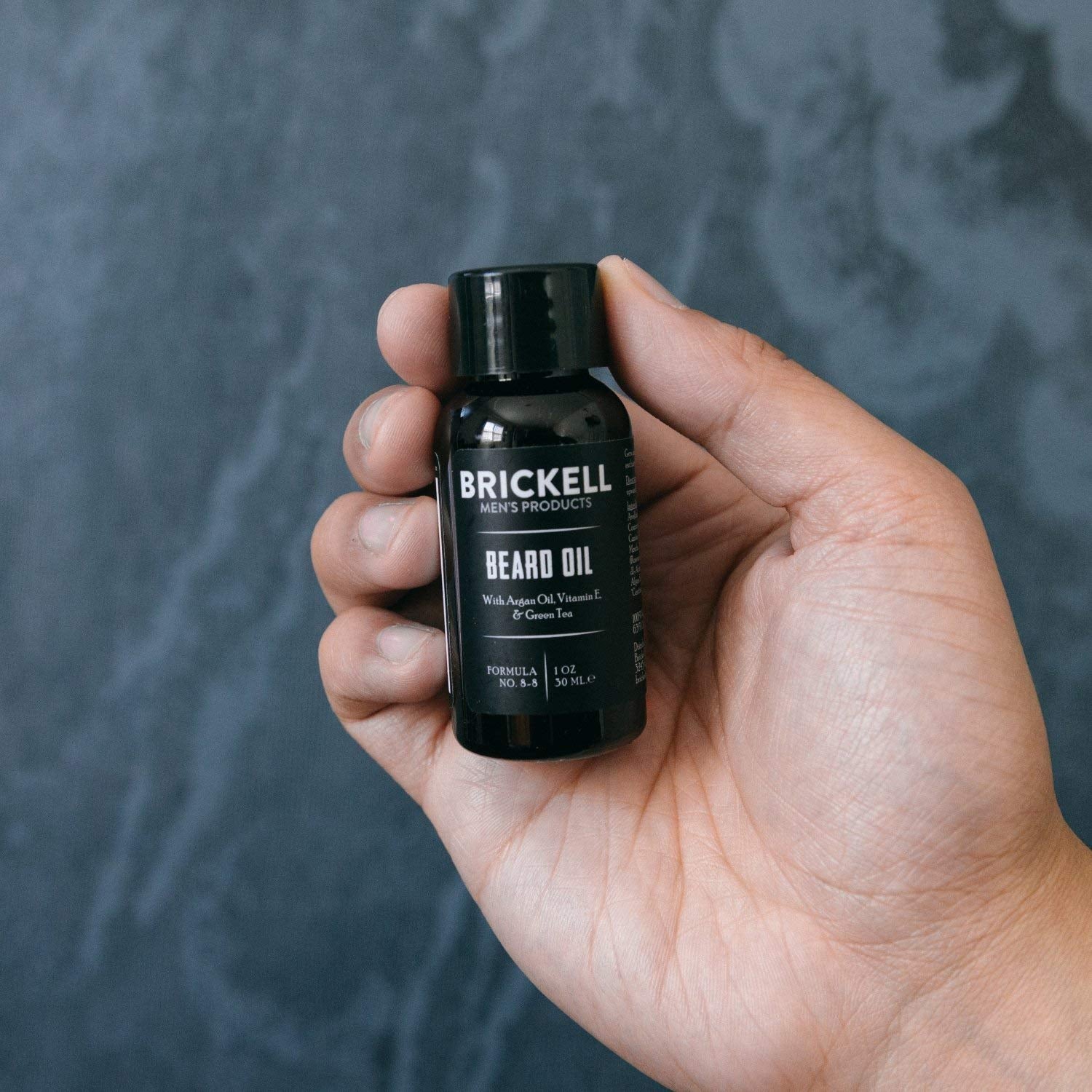 Brickell Men’s Beard Oil jar close-up on a countertop.