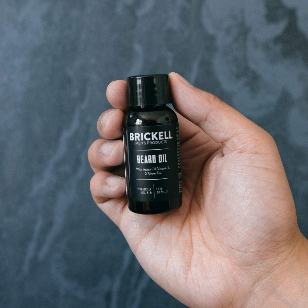 Brickell Men’s Beard Oil jar close-up on a countertop.