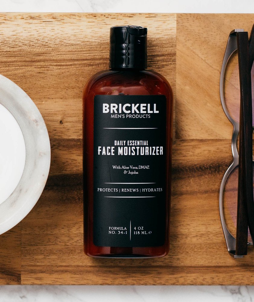 Brickell Men's Daily Essential moisturizer being applied to skin for non-greasy absorption.