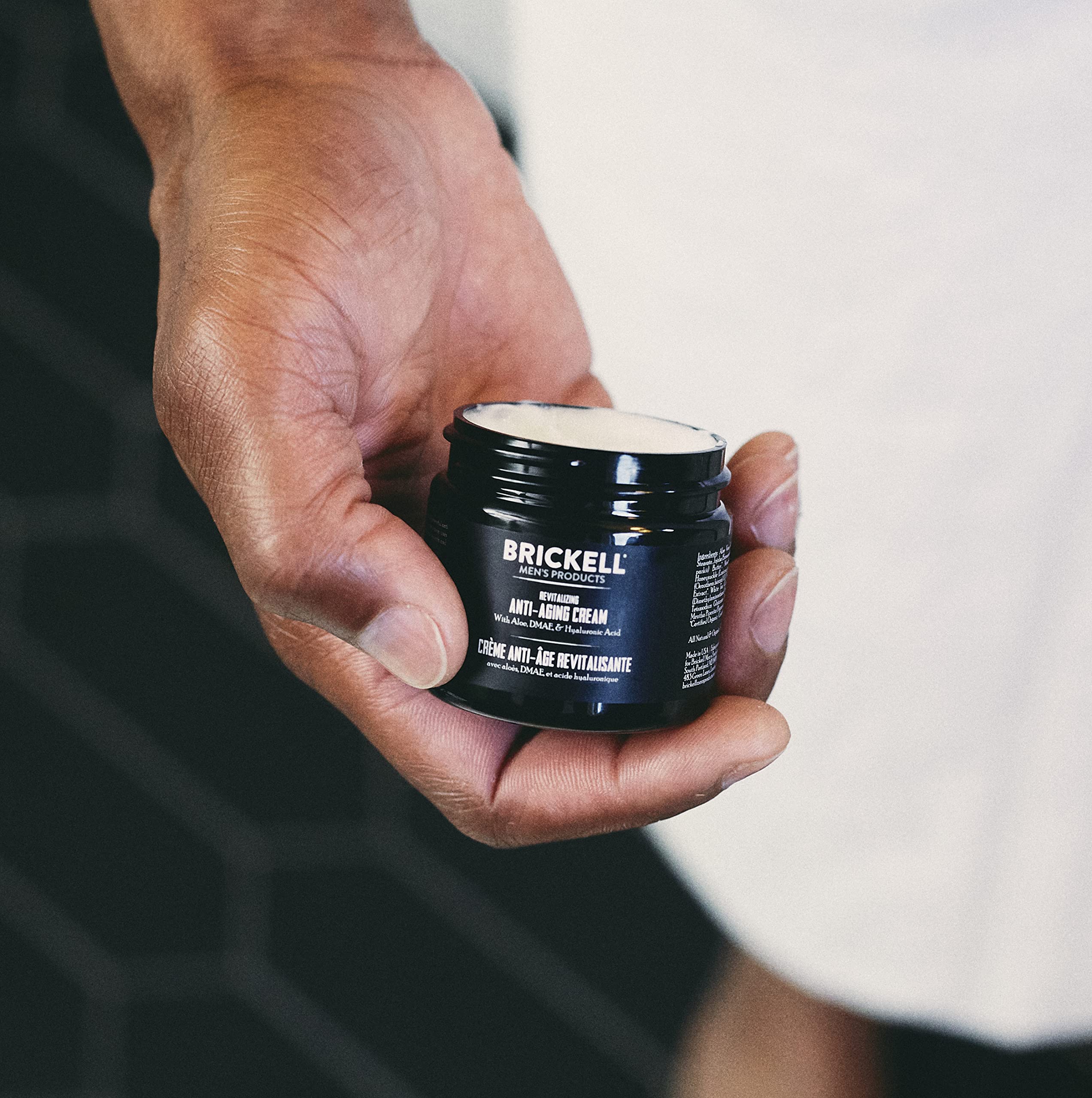 Brickell Men's Day and Night routine tube closeup highlights anti-aging benefits and smooth texture.