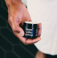 Brickell Men's Day and Night routine tube closeup highlights anti-aging benefits and smooth texture.