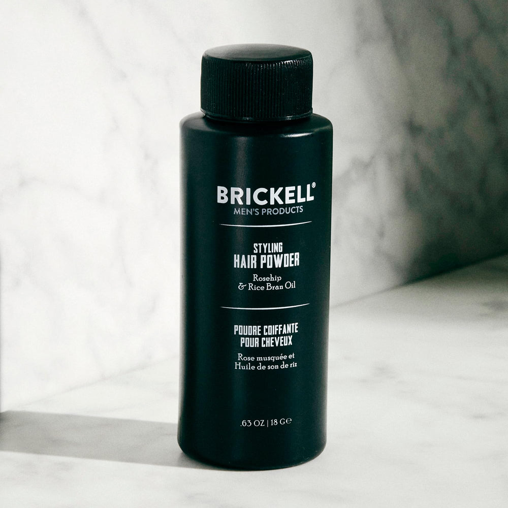 Brickell Men's Styling Hair Powder applying as a light dust for textured hair.