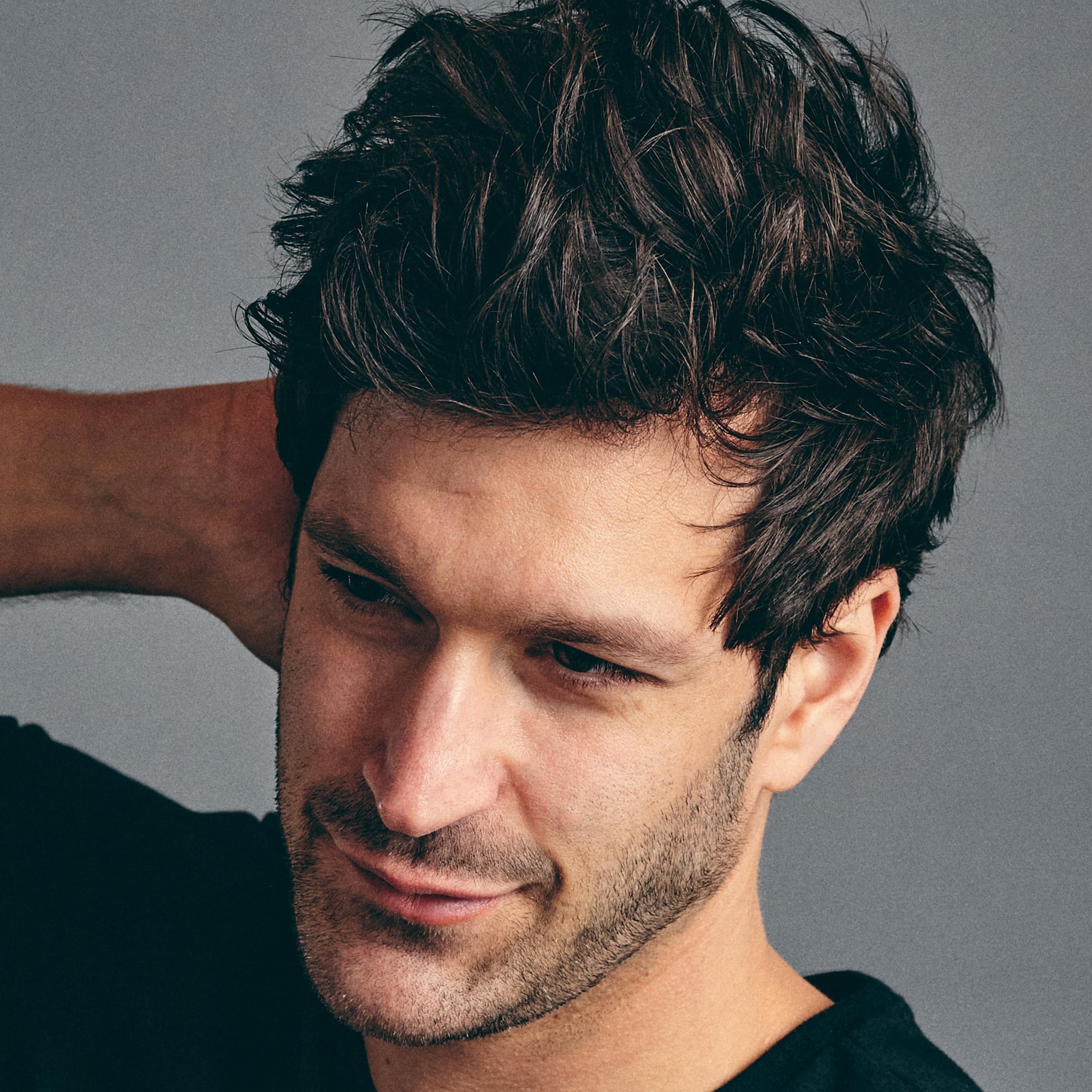 A man using Brickell styling powder for volume and hold.