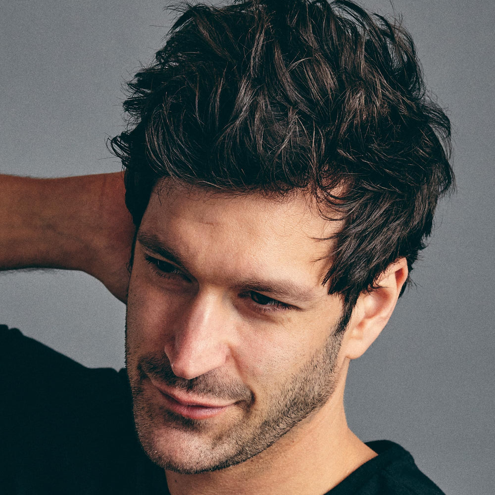 A man using Brickell styling powder for volume and hold.