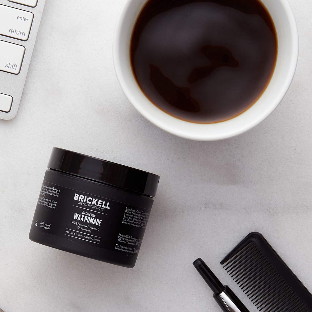 Brickell Men's wax pomade on hands illustrates easy application and conditioning.