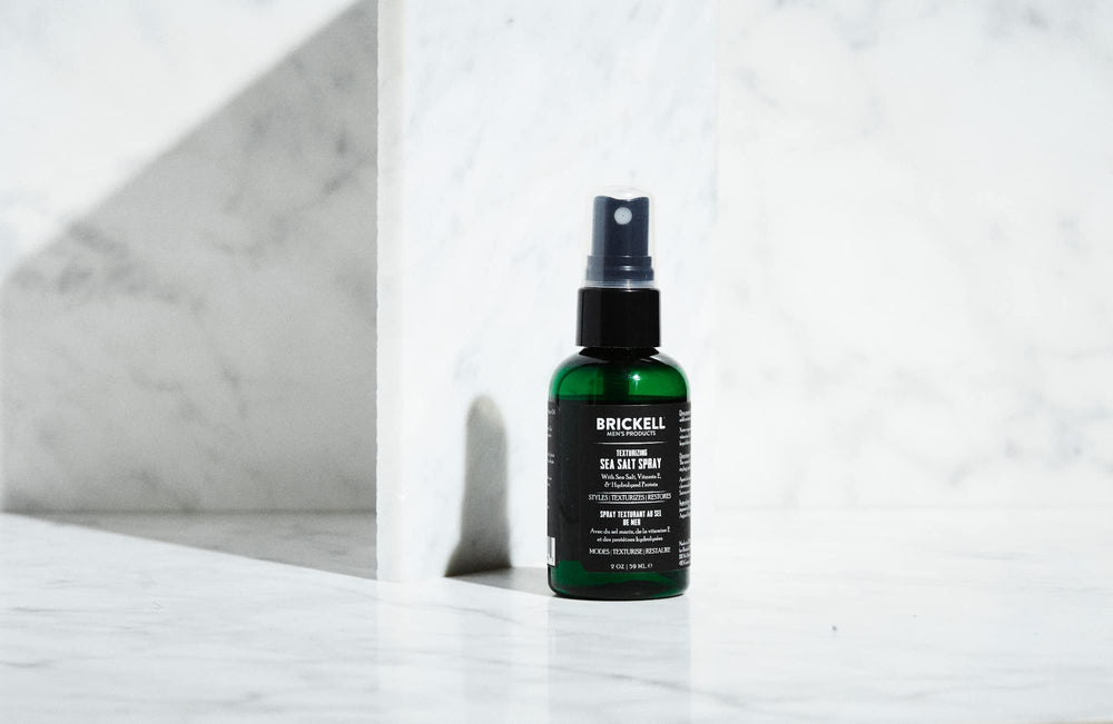 Brickell Men's Texturizing Sea Salt Spray on hair showing relaxed waves and volume.