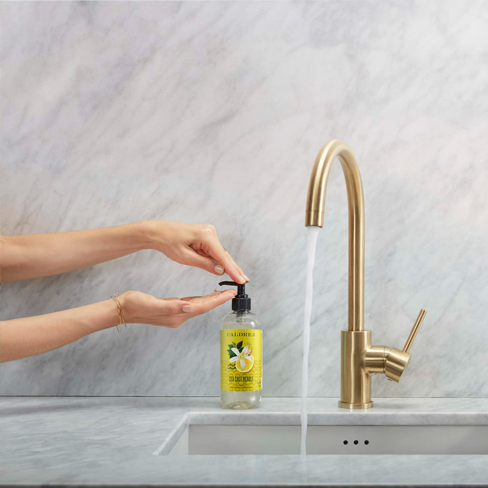 Caldrea Sea Salt Neroli foaming hand wash on sink with rinsing action.