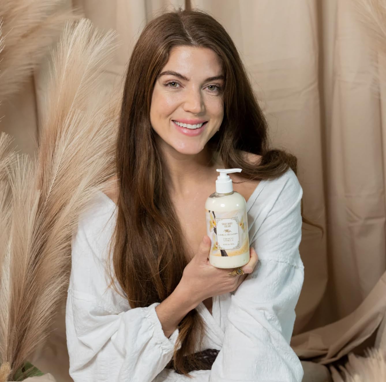 Hands applying Camille Beckman cream for daily moisturization and smooth skin.