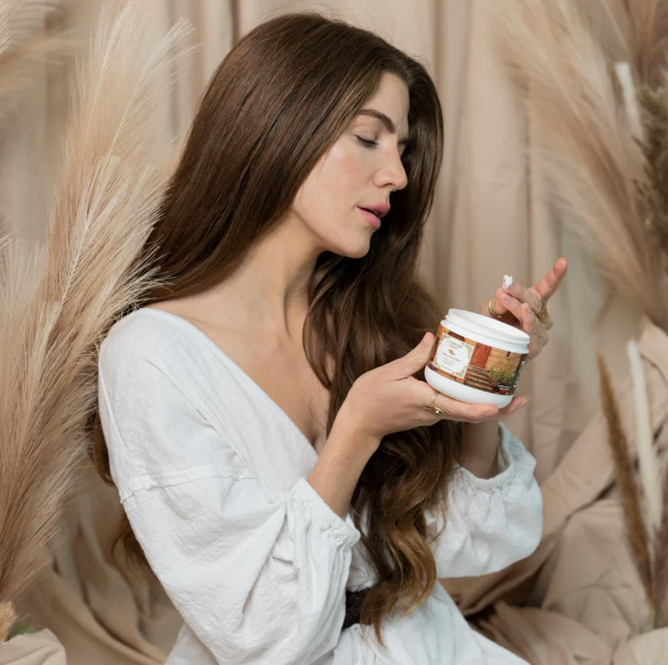 Camille Beckman glycerine hand therapy cream bottle on shelf emphasizes long-lasting hydration.