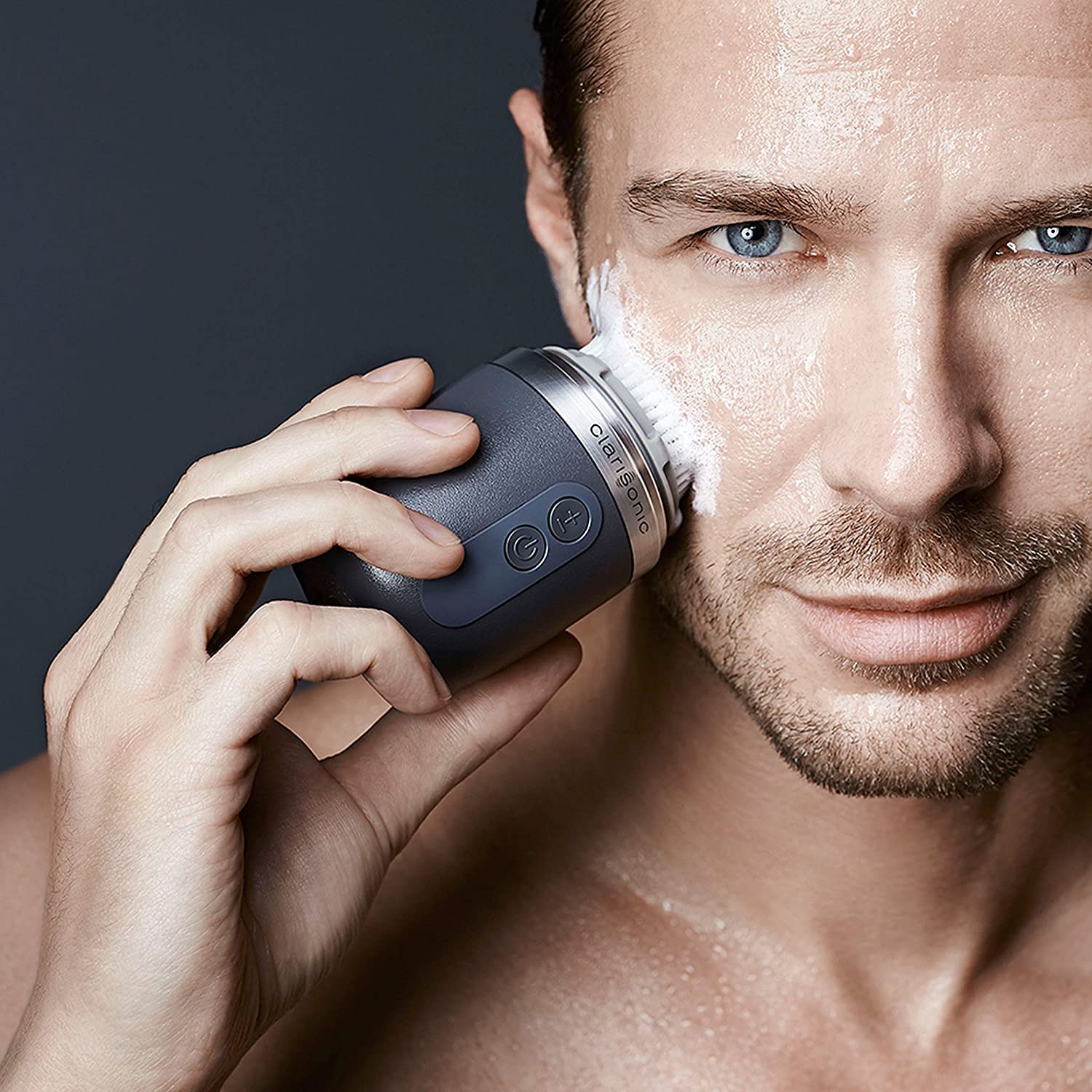 Grey Clarisonic Alpha FIT in use during daily routine with cleansing motion.
