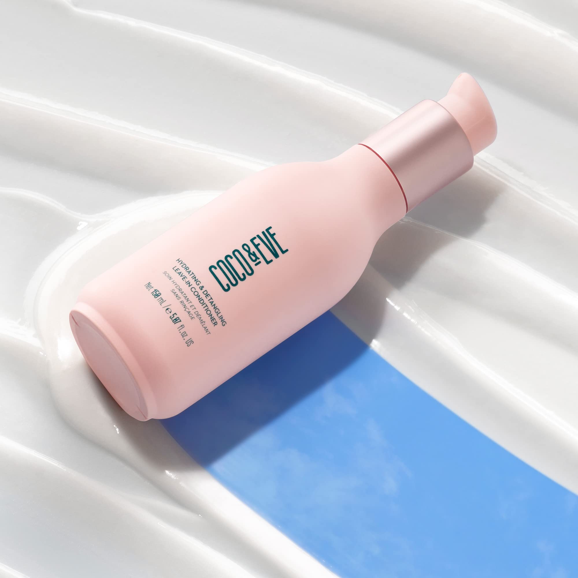 Coco & Eve leave-in conditioner bottle pour shows easy detangling.