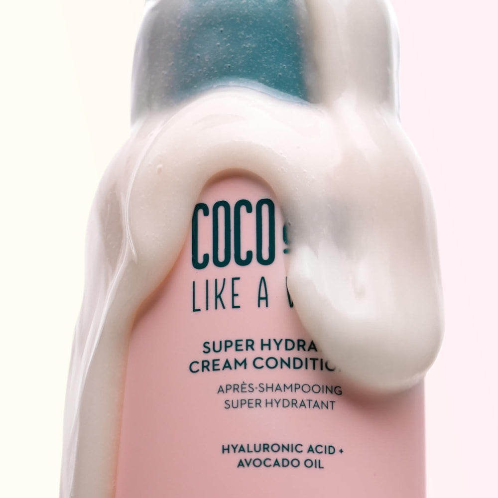 Coco & Eve Like A Virgin applying conditioner to hair for detangling ease.
