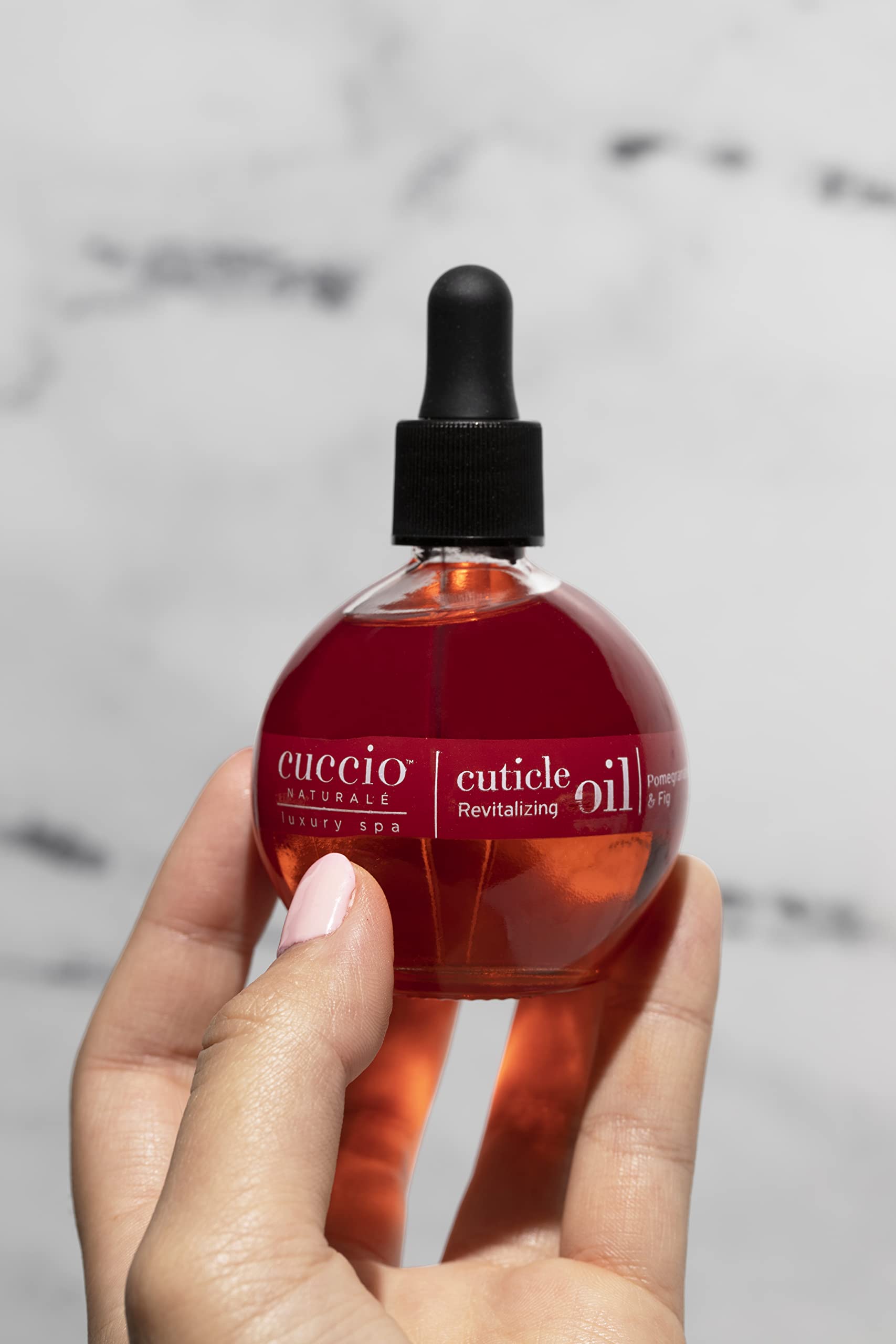 Cuccio Naturale Revitalizing Cuticle Oil being applied to cuticles and nails for care.