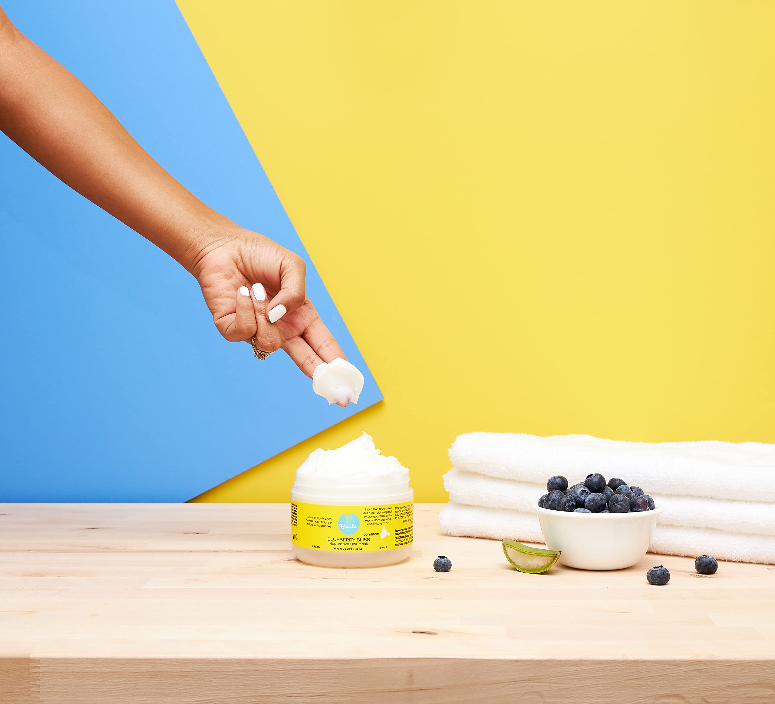 Curls Blueberry Bliss in-shower application shows detangling and conditioning for frizz-free curls.