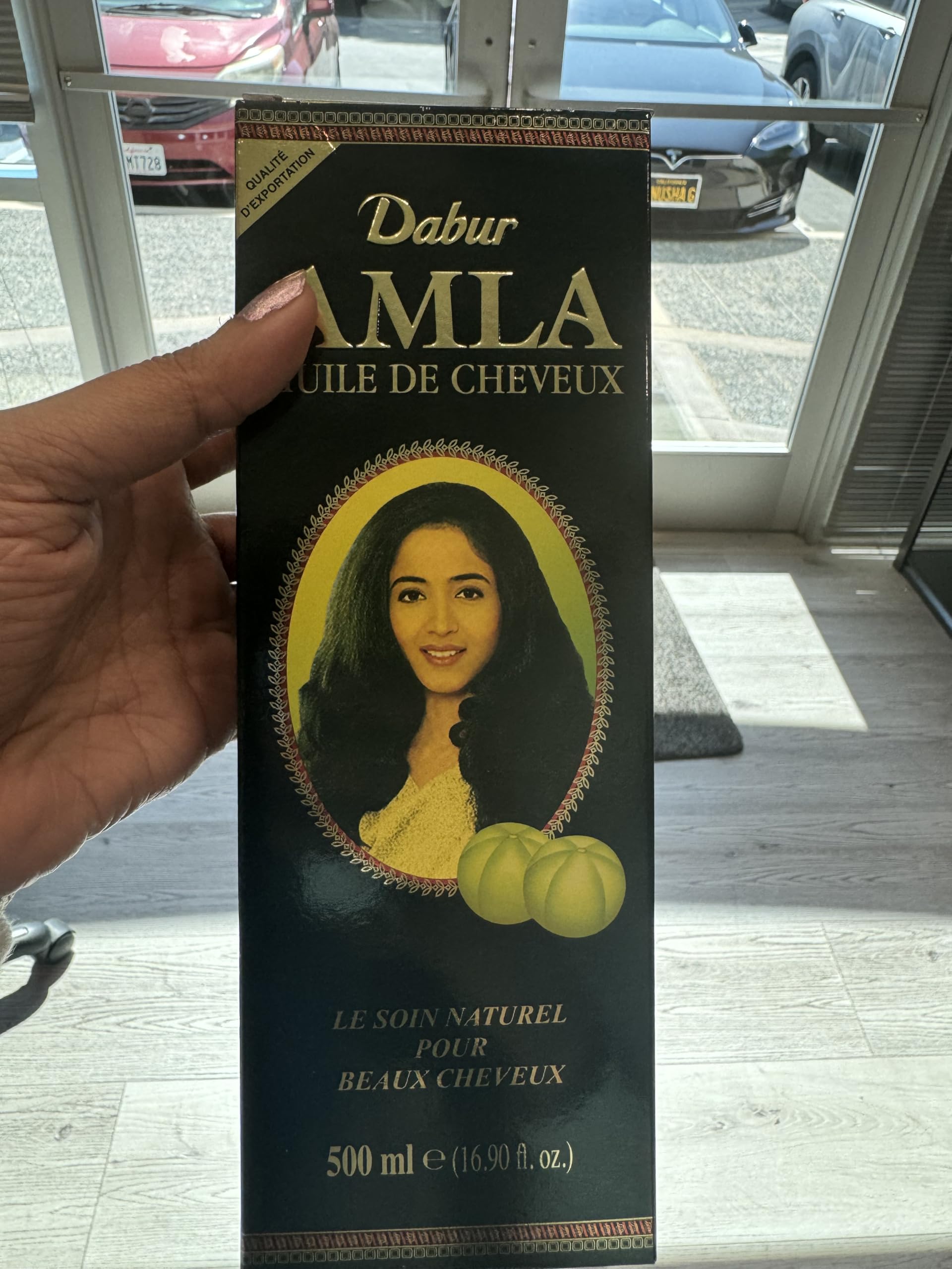 Dabur Amla Hair Oil close-up shows amla extract for scalp nourishment.