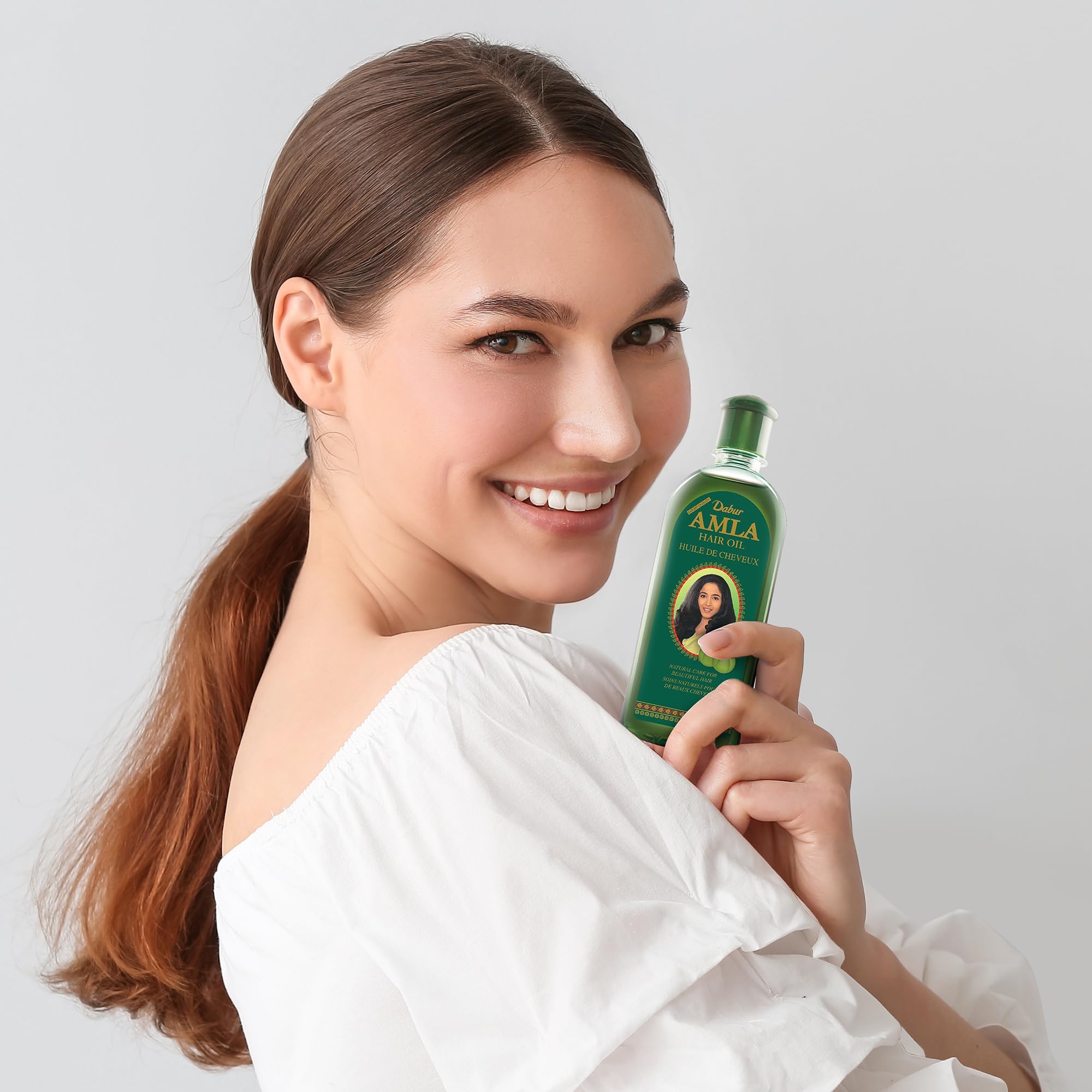 Dabur Amla Hair Oil application scene emphasizes gentle scalp massage and absorption