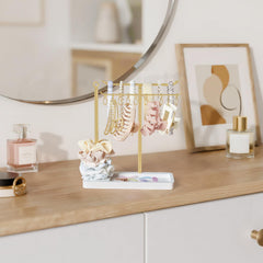 Dahey headband holder base with grooves in gold for extra accessory storage.