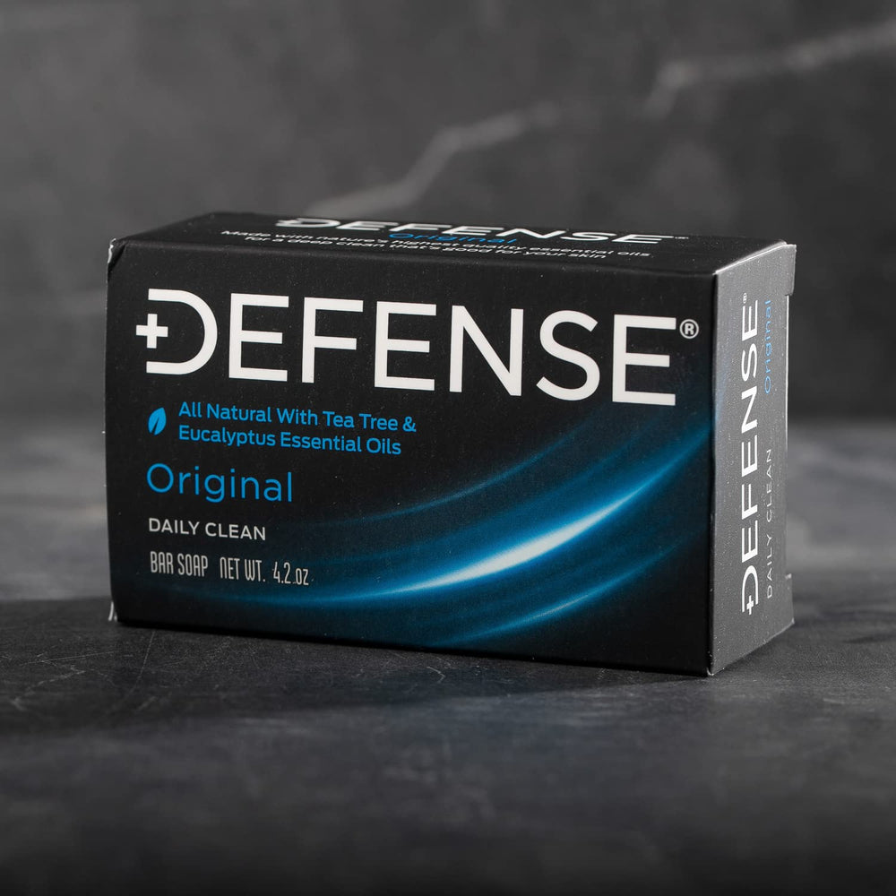 Defense Soap tea tree bar stacked on shower shelf for athletes' daily cleansing.