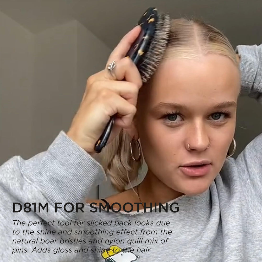 Denman D81M ergonomic handle in-hand use, offering control during daily styling.