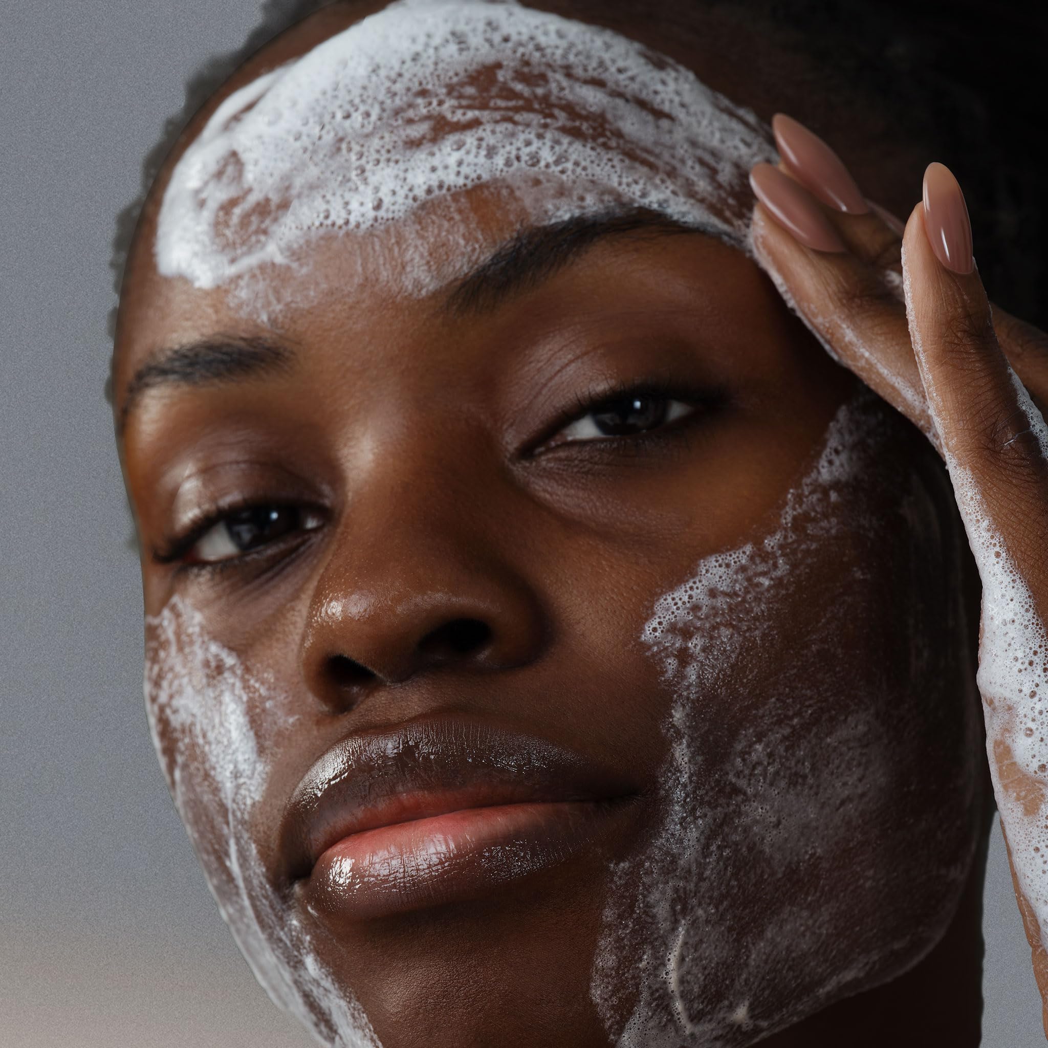 Dermalogica Clear and Brighten Kit serum dropper applying on cheek glow.