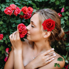 Dizila red rose hair clip accents an updo for prom night.