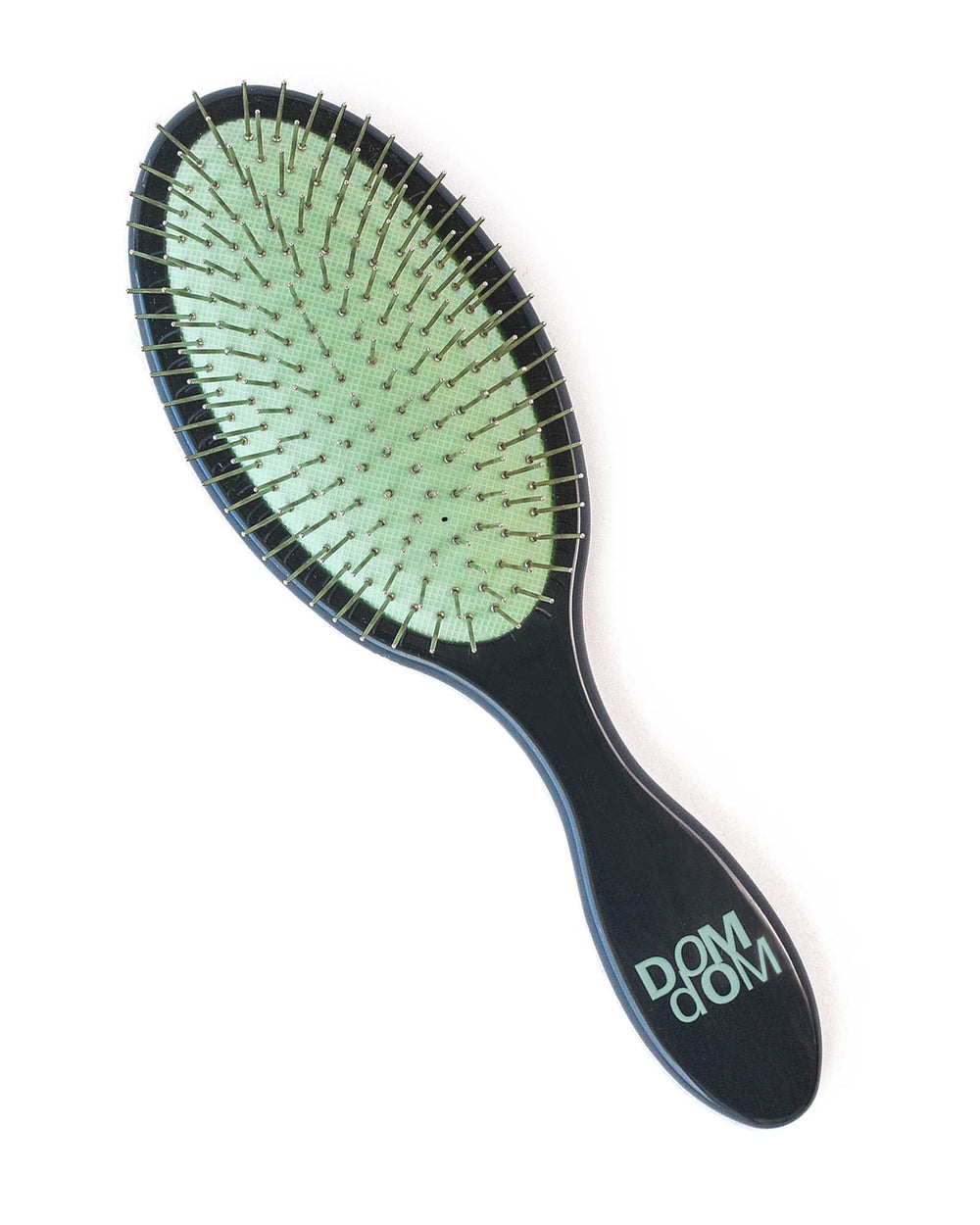 Dom Dom detangling brush on damp hair, lightweight travel-friendly design.