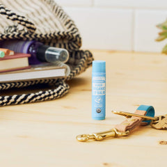Close-up of Dr. Bronner's lip balm tube with hydrating formula for dry lips