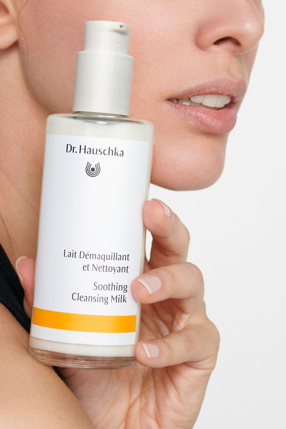 Dr. Hauschka Soothing Cleansing Milk pump-dispense in use on cotton pad