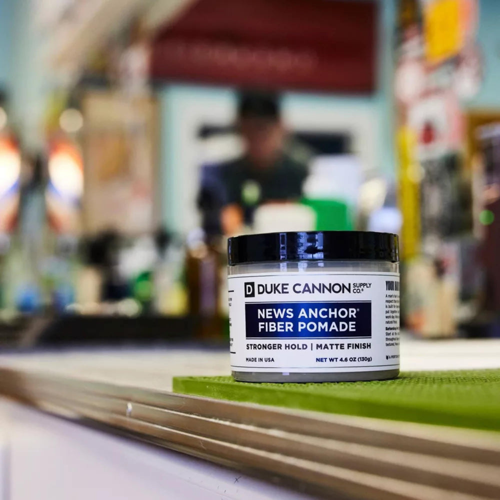 Duke Cannon News Anchor Fiber Pomade hands applying for easy restyling.