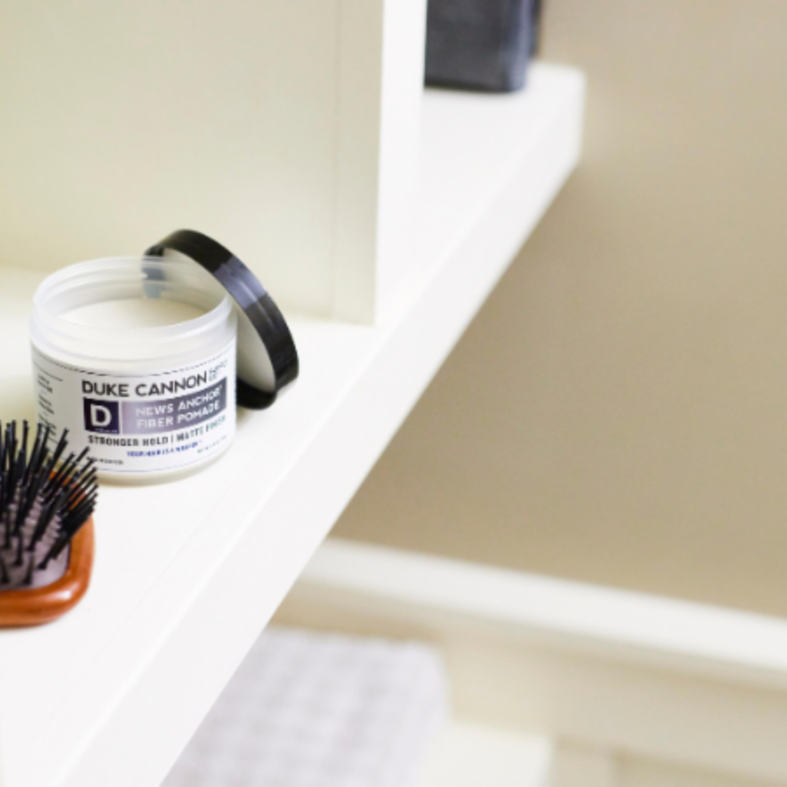 Duke Cannon News Anchor Fiber Pomade USA-made branding closeup.