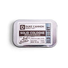 Duke Cannon Old Glory solid cologne tin front view for on-the-go freshness.