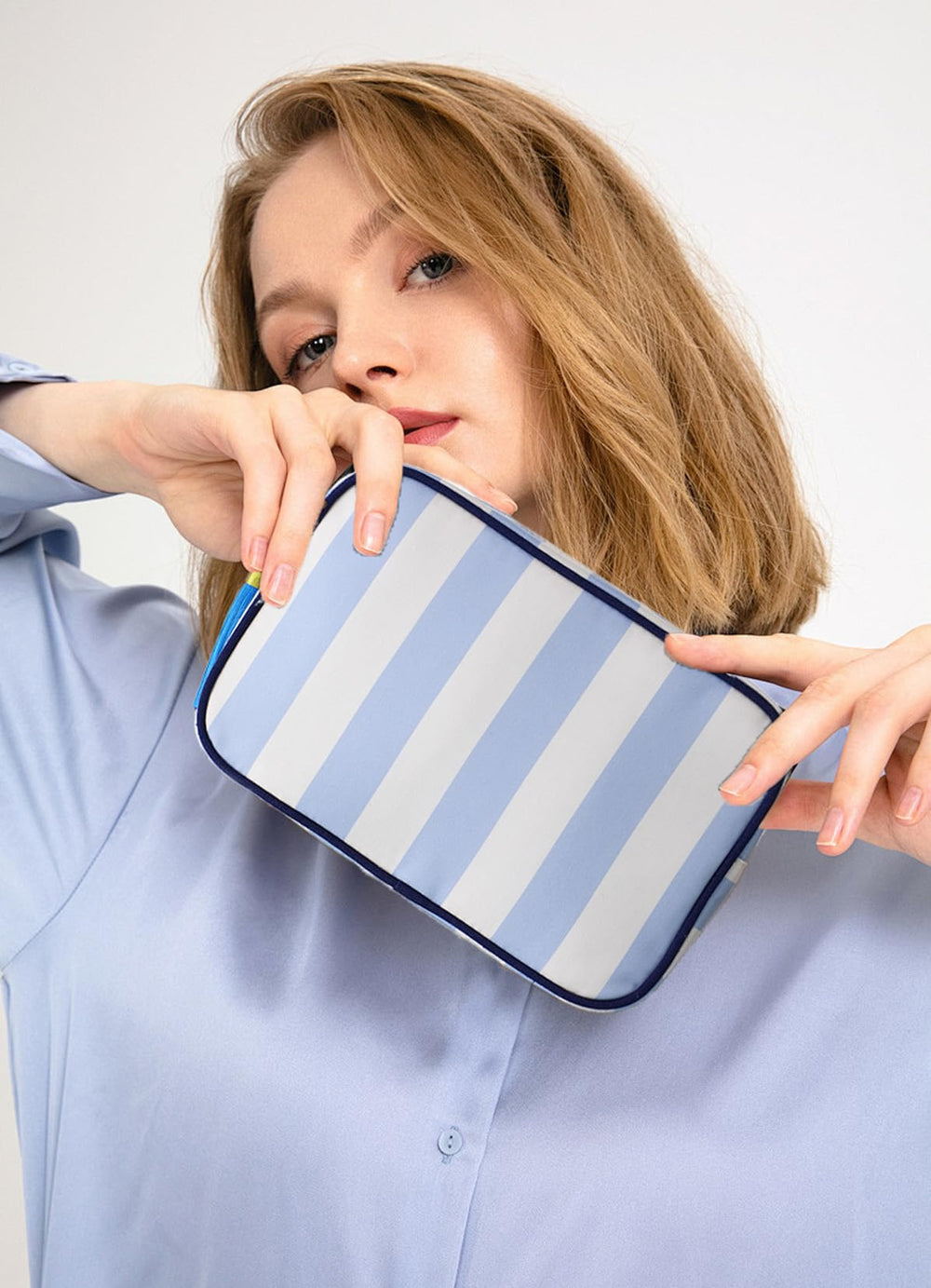 EMBRUNIOICE stripe makeup bag tassel zipper detail highlights stylish organization.