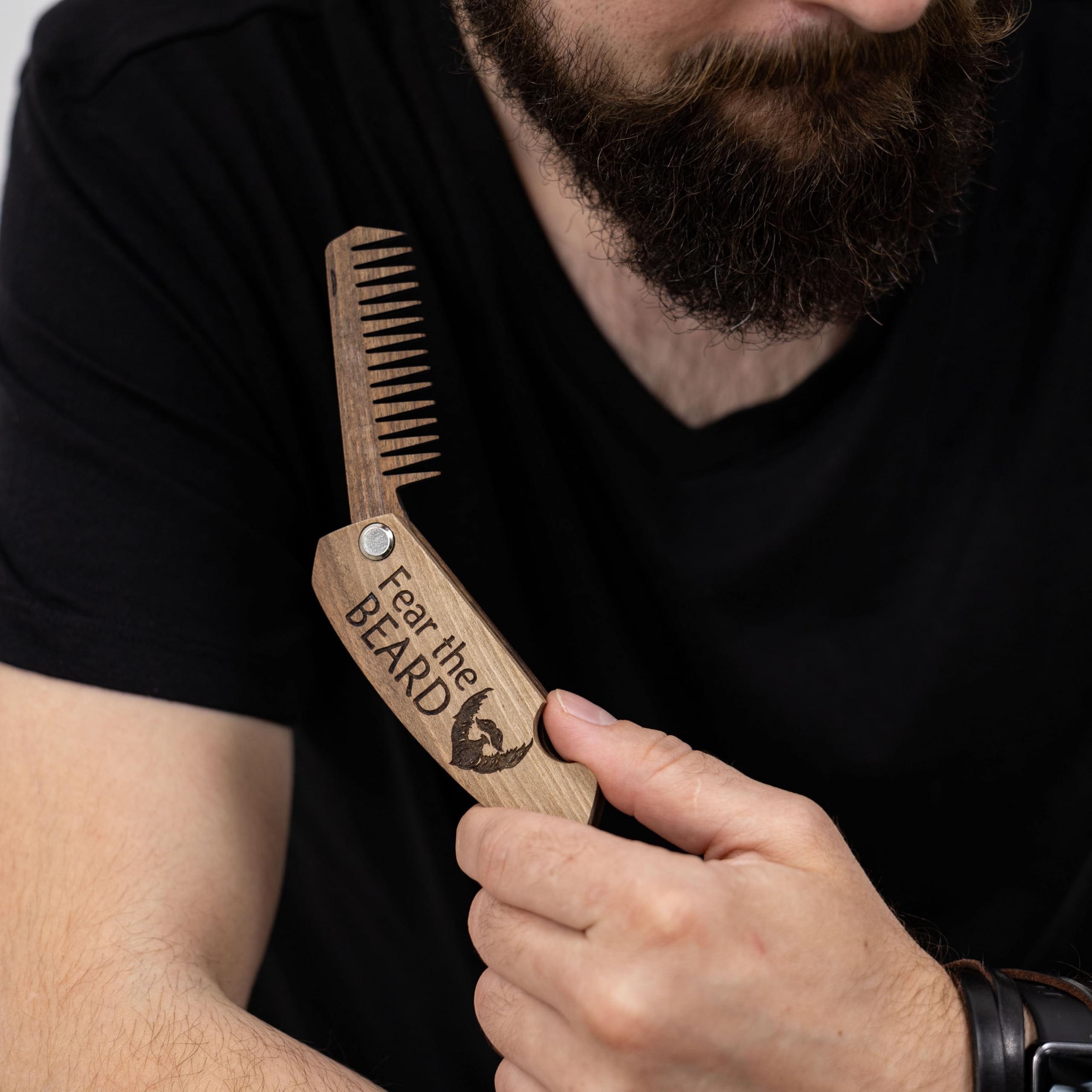 Enjoy The Wood beard comb in use for smoothing and detangling hair.