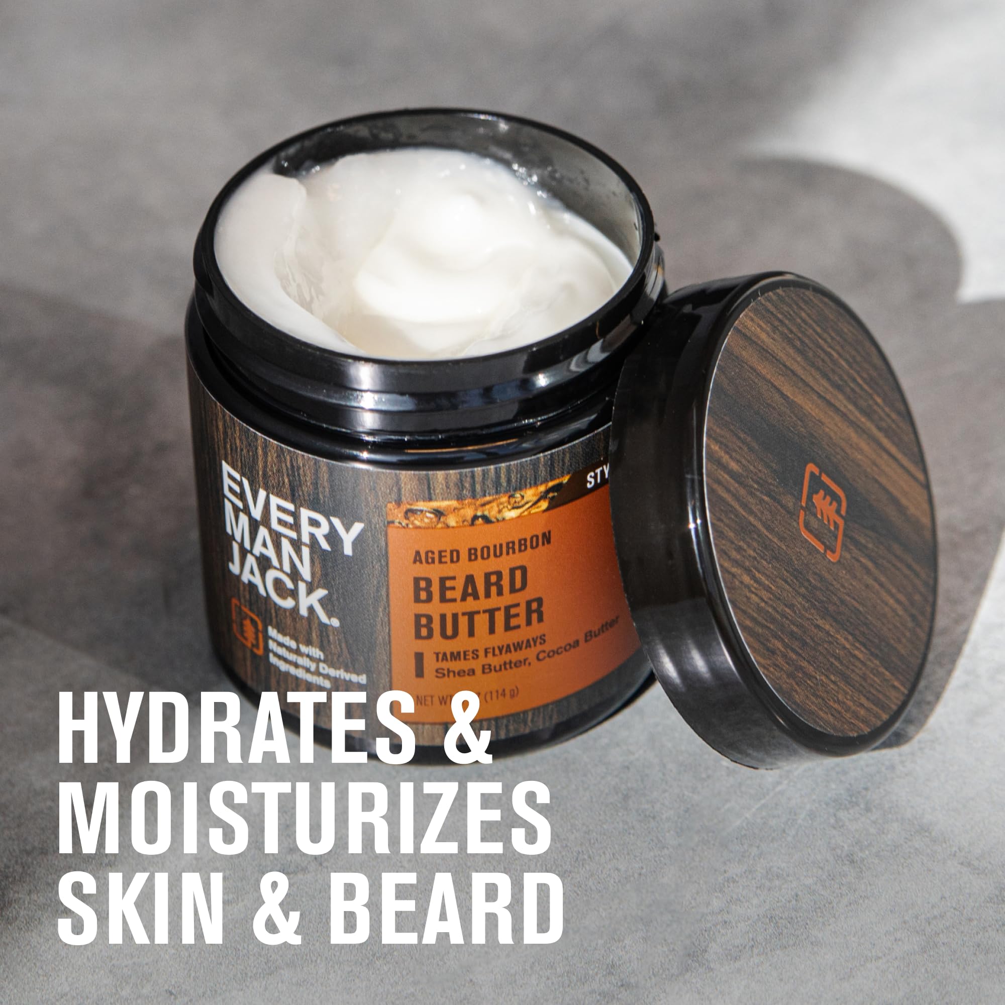 Every Man Jack aged bourbon beard butter packaging on wood for premium grooming.