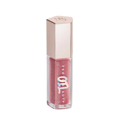 Fenty Beauty Gloss Bomb Lip Oil bottle glowing with rosy shimmer and hydration.
