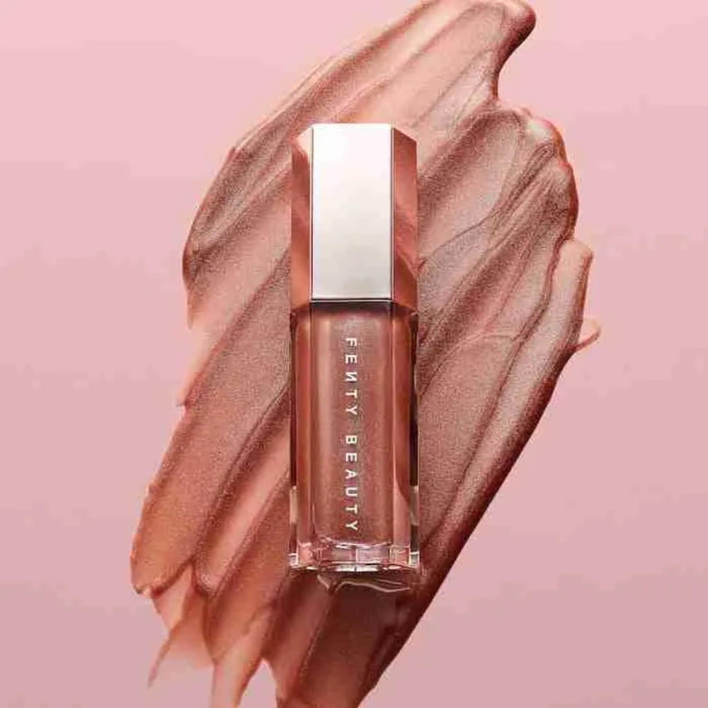 FENTY BEAUTY Gloss Bomb 01 purse-size mini in hand for travel-ready shine