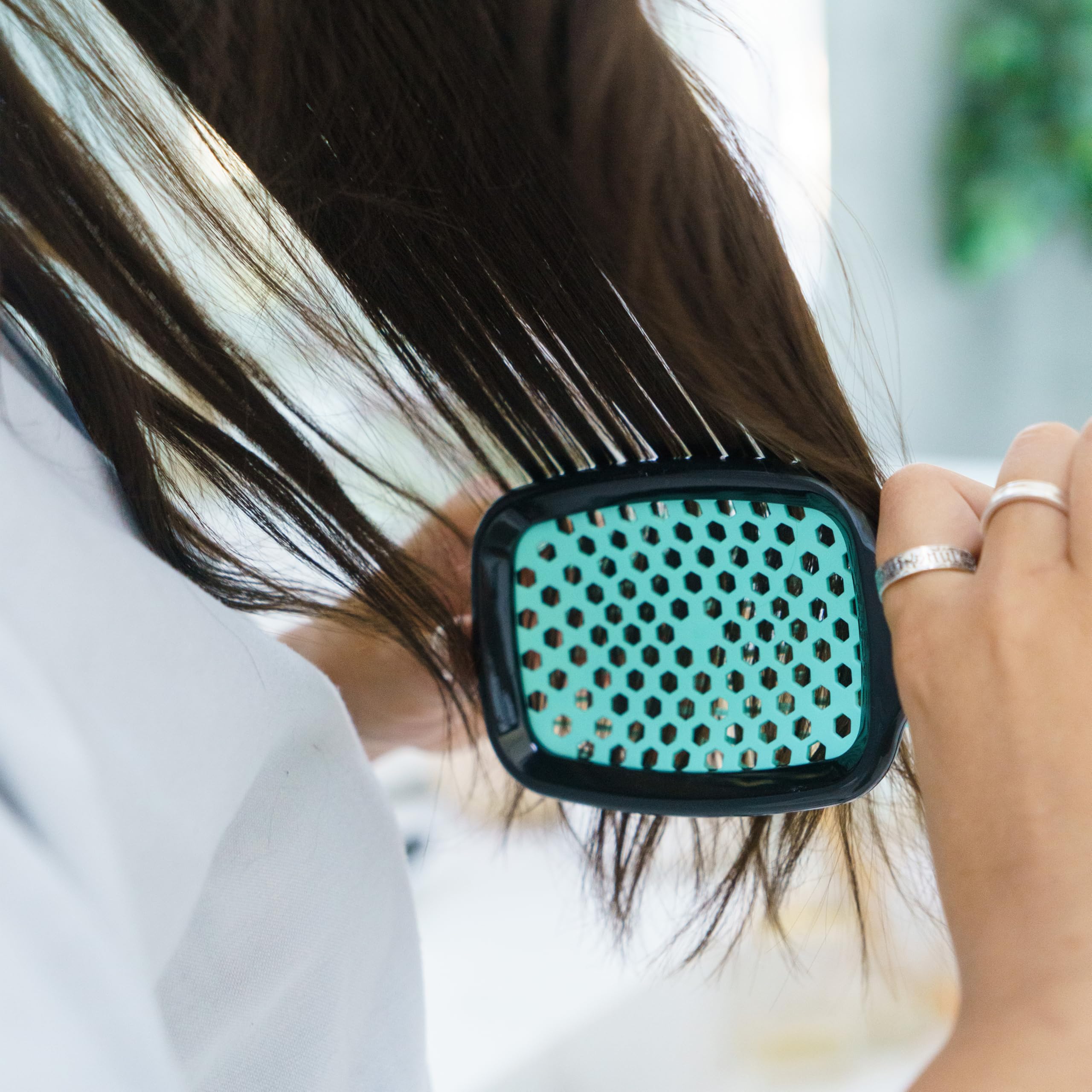 FHI Heat UNbrush in hand highlights compact travel-friendly detangler