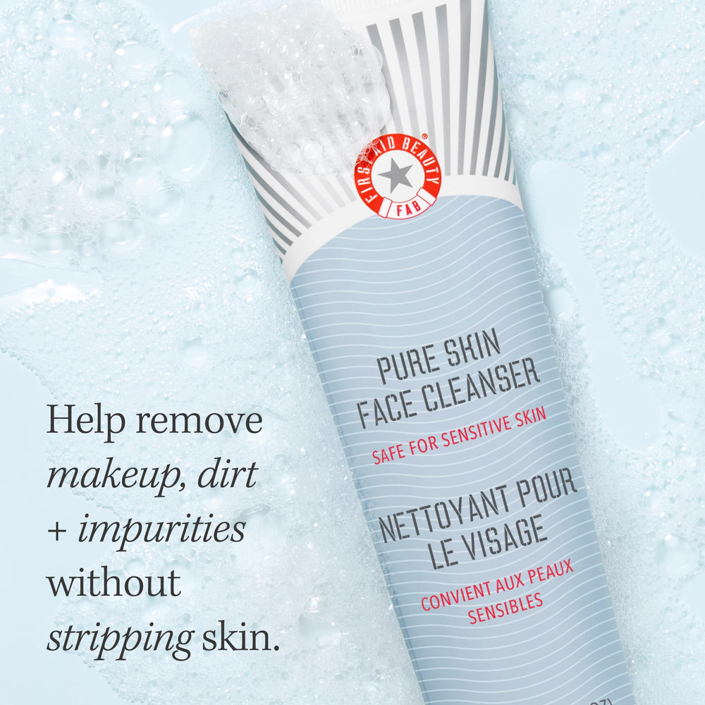 First Aid Beauty Pure Skin Face Cleanser foaming action on skin with towel backdrop.