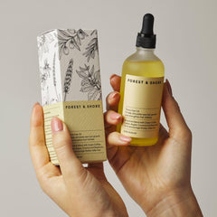 Forest & Shore Hair Growth Oil on hand demonstrating lightweight application for scalp care