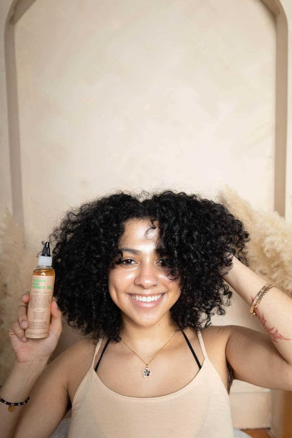 Glossed by Nae Voodoo Hair Growth Oil droplet on hair shows lightweight, non-greasy feel