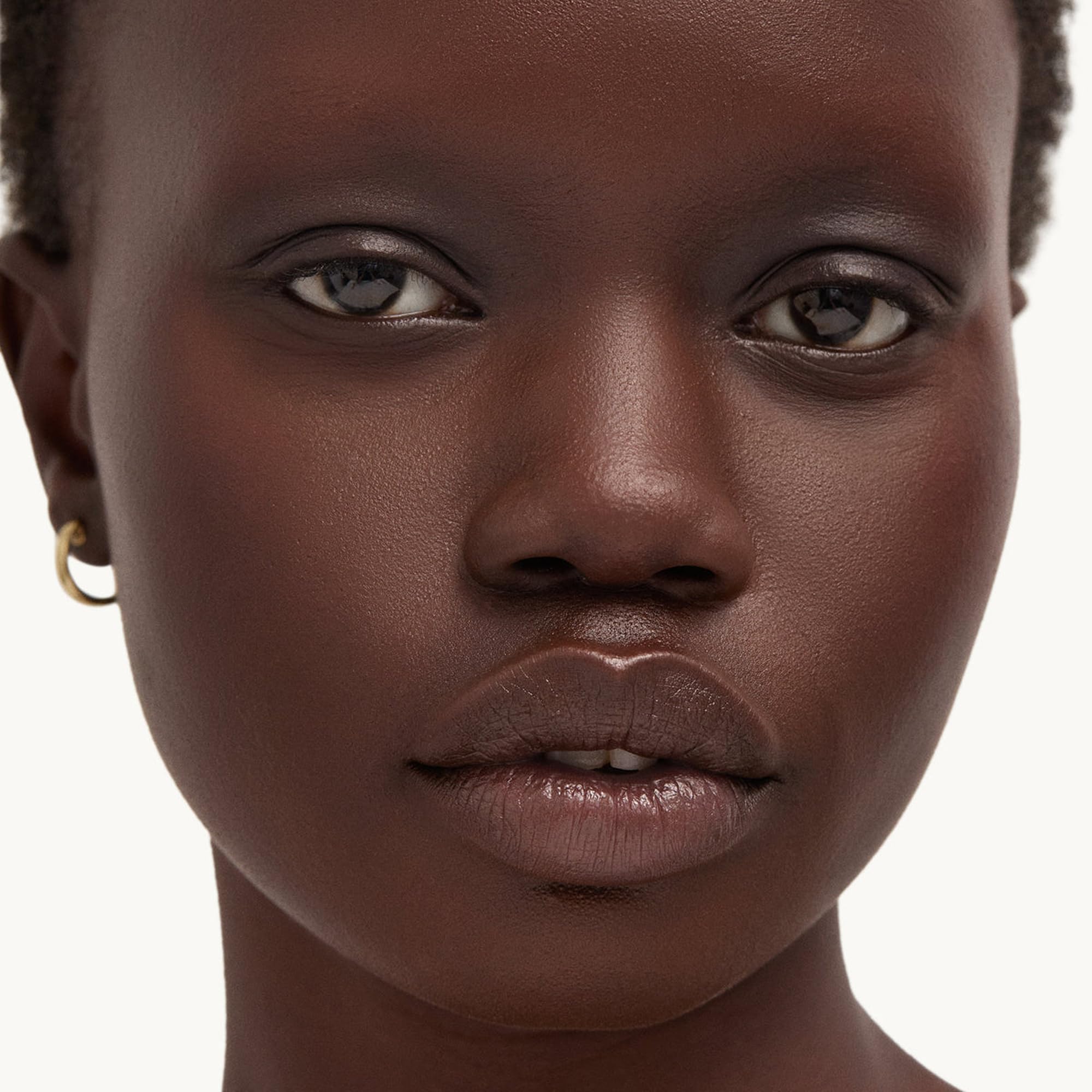 Goop Beauty Cleansing Balm melting from balm to oil shown on skin.