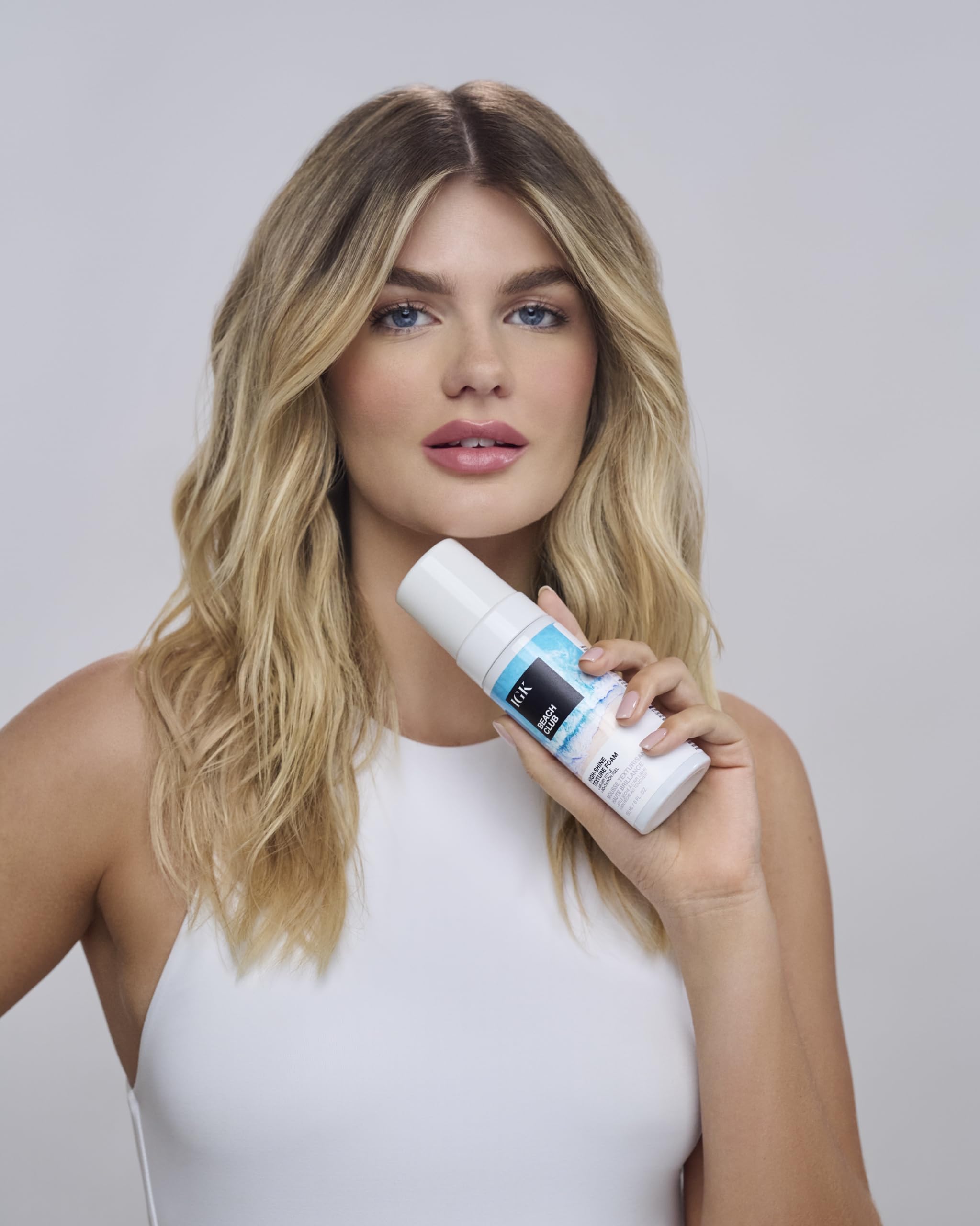 IGK Beach Club Texture Foam being scrunched into damp hair for texture.