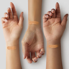 ILIA Super Serum Skin Tint being applied to cheek demonstrates lightweight, buildable coverage.